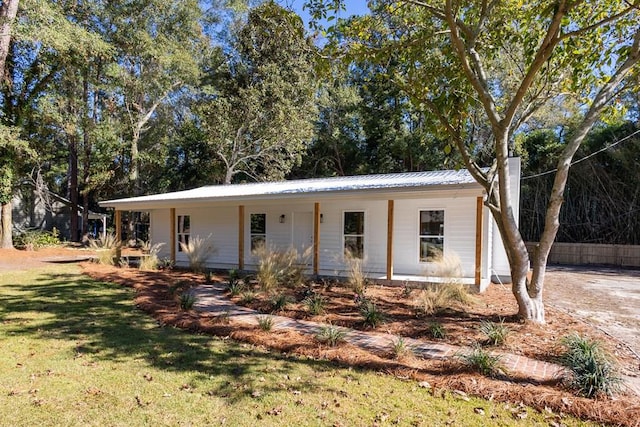 view of front of property with metal roof and a front lawn