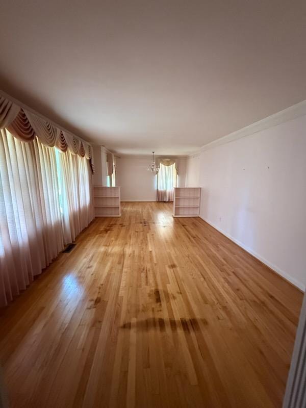 221 Maury St, Thomasville, GA 31792 - unfurnished living room with a chandelier and light wood-style flooring