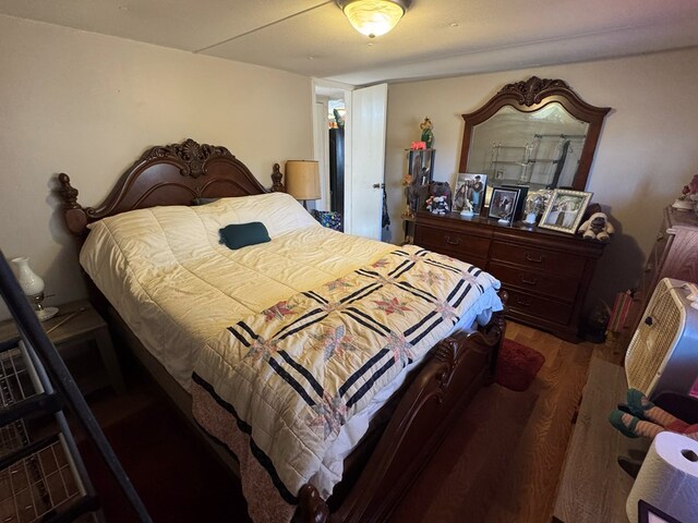 bedroom with dark hardwood / wood-style floors