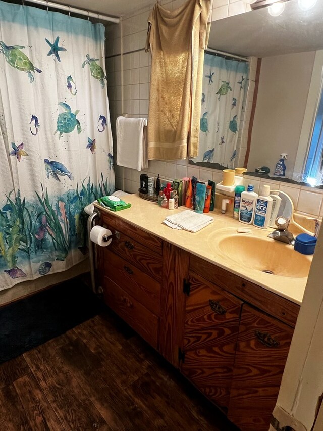 bathroom with tasteful backsplash, shower / tub combo with curtain, wood-type flooring, and vanity