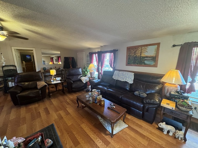 living room featuring ceiling fan, wood-type flooring, and a textured ceiling