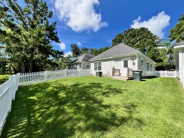 back of house with central AC and a lawn