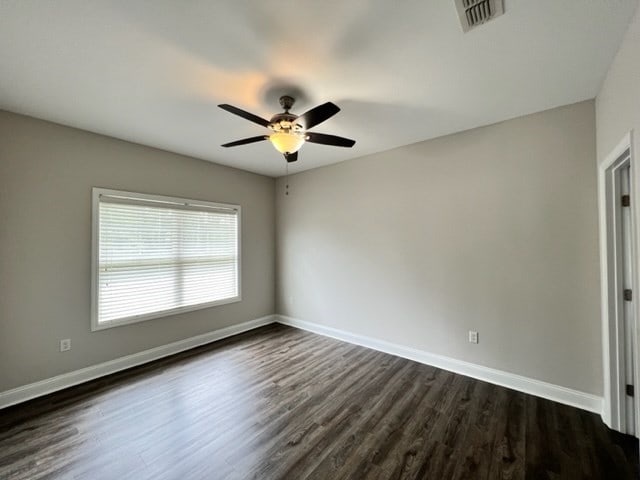 empty room featuring dark hardwood / wood-style floors and ceiling fan