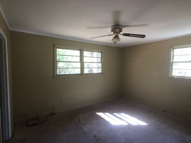 spare room featuring a ceiling fan, crown molding, and baseboards