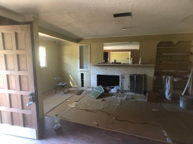 unfurnished living room featuring a brick fireplace