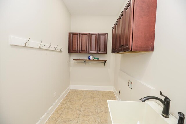 clothes washing area featuring sink, cabinets, light tile patterned floors, hookup for a washing machine, and electric dryer hookup