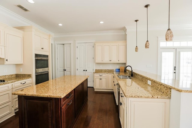 kitchen with pendant lighting, sink, light stone counters, kitchen peninsula, and stainless steel double oven