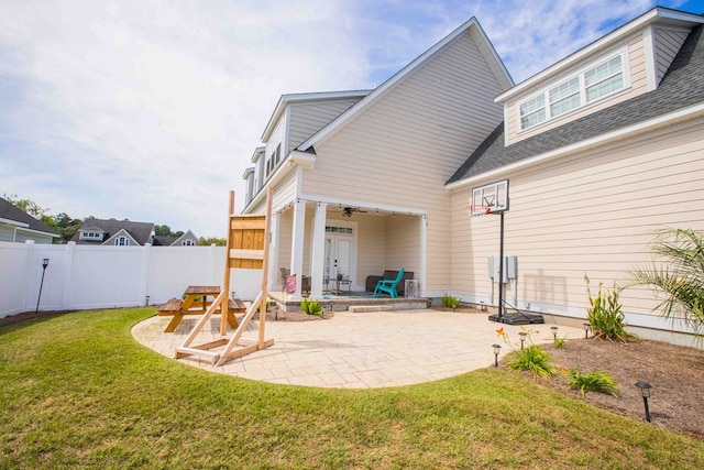 rear view of property with a yard, ceiling fan, and a patio area