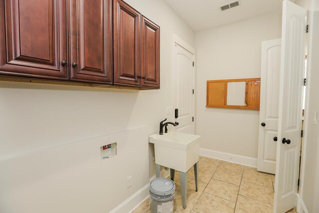 laundry room with cabinets, washer hookup, and light tile patterned floors