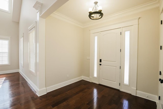 foyer with ornamental molding, dark wood-type flooring, and a notable chandelier