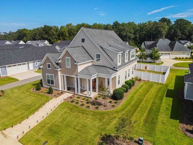 view of front of home with a garage, a porch, and a front yard