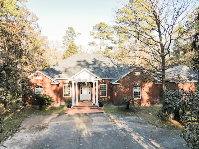 neoclassical / greek revival house with brick siding and a shingled roof