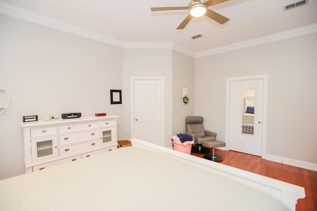 interior space with wood finished floors, visible vents, and ornamental molding