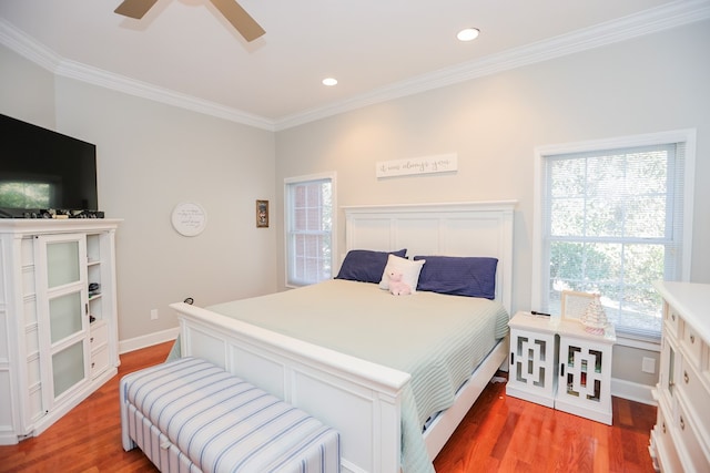 bedroom with crown molding, baseboards, and wood finished floors