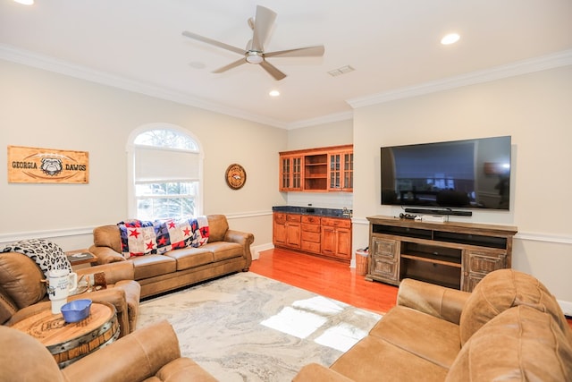 living area with visible vents, recessed lighting, ceiling fan, ornamental molding, and light wood-style floors