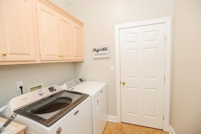 clothes washing area with baseboards, cabinet space, and washer and clothes dryer