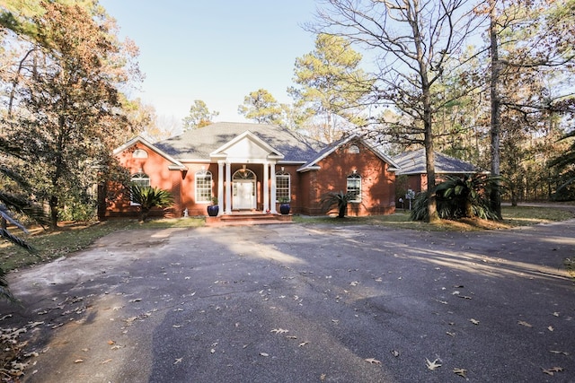 greek revival house with aphalt driveway