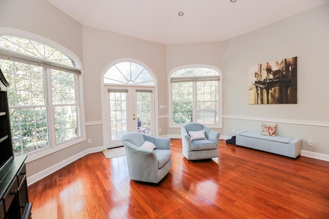 sitting room featuring plenty of natural light, french doors, baseboards, and hardwood / wood-style floors