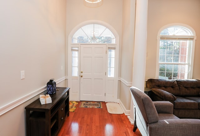 entrance foyer featuring a high ceiling, baseboards, and wood finished floors