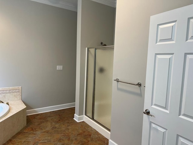 bathroom with a shower stall, baseboards, a garden tub, and ornamental molding