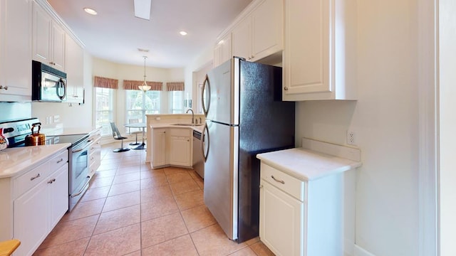 139 Summercreek Cv, Thomasville, GA 31792 - kitchen with stainless steel appliances, light countertops, white cabinetry, recessed lighting, and decorative light fixtures