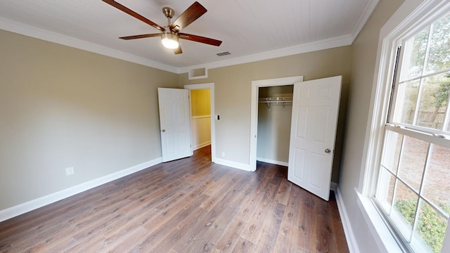 unfurnished bedroom featuring ornamental molding, ceiling fan, dark hardwood / wood-style flooring, and a closet