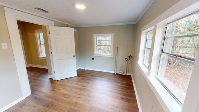 empty room with crown molding and dark hardwood / wood-style floors