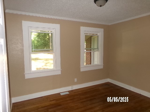 320 Camellia Ct, Camilla, GA 31730 - spare room featuring baseboards, ornamental molding, a textured ceiling, and wood finished floors