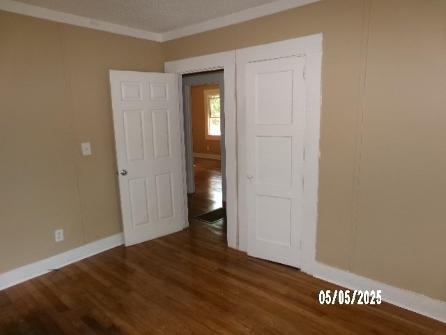 320 Camellia Ct, Camilla, GA 31730 - unfurnished bedroom featuring baseboards and dark wood-type flooring