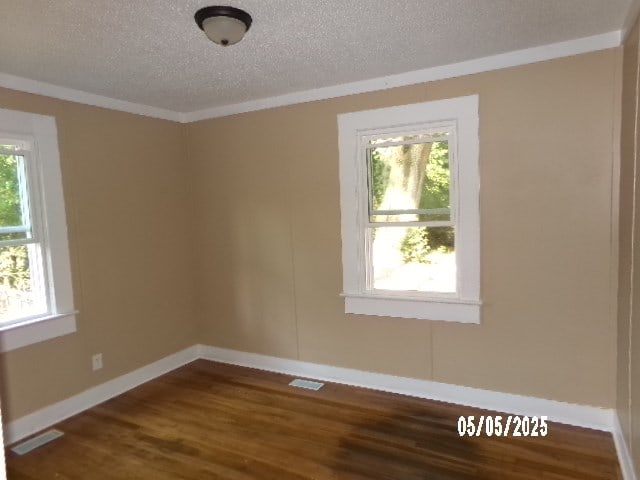 320 Camellia Ct, Camilla, GA 31730 - spare room featuring a textured ceiling, dark wood finished floors, visible vents, and plenty of natural light