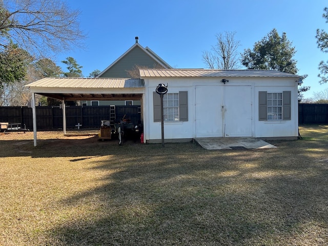 view of outbuilding featuring a carport and fence