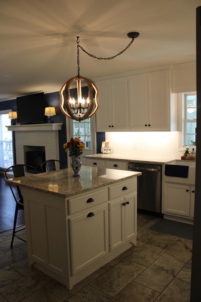 kitchen with a healthy amount of sunlight, dishwashing machine, and white cabinetry