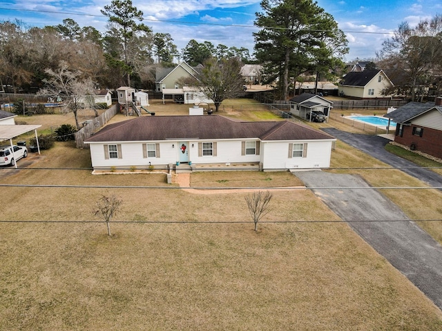 view of front of home featuring fence, driveway, and a front lawn