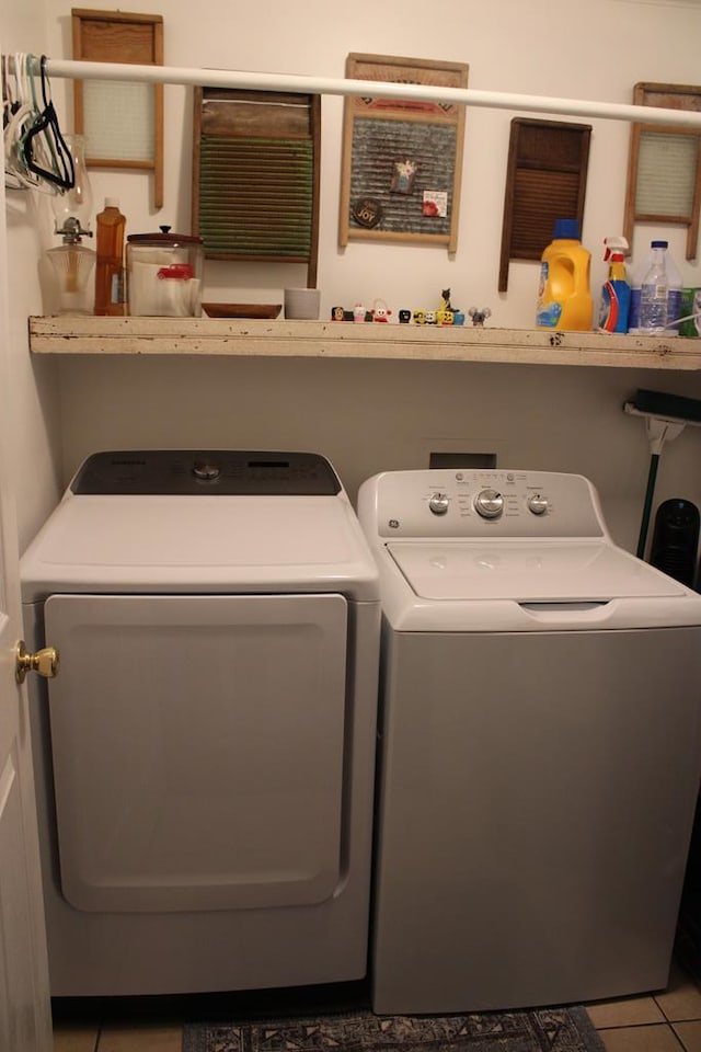 laundry room with laundry area, washer and clothes dryer, and tile patterned flooring