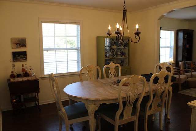 dining space featuring arched walkways, plenty of natural light, dark wood-style floors, and crown molding