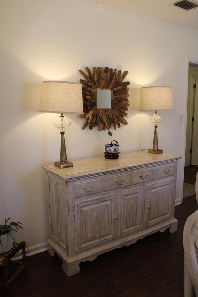 details featuring baseboards, crown molding, visible vents, and wood finished floors