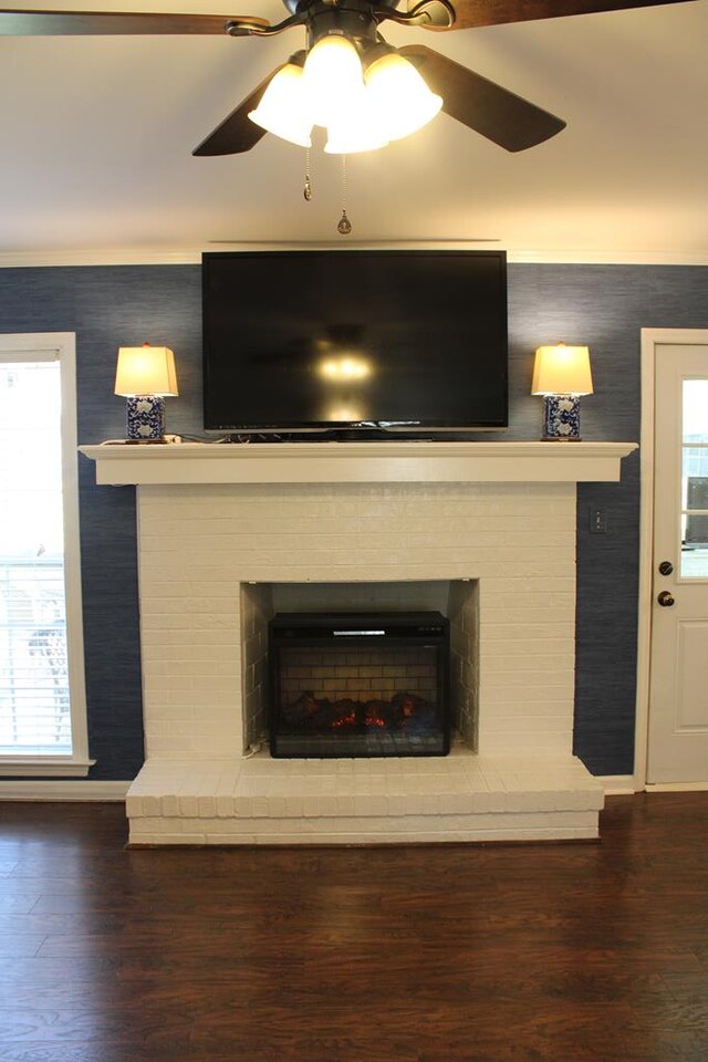 details featuring baseboards, a fireplace, a ceiling fan, and wood finished floors