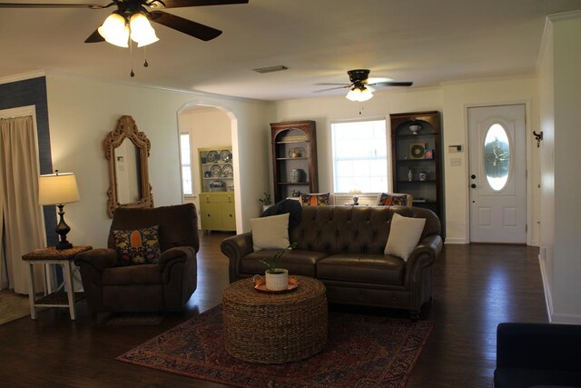 living room with arched walkways, wood finished floors, visible vents, and a healthy amount of sunlight