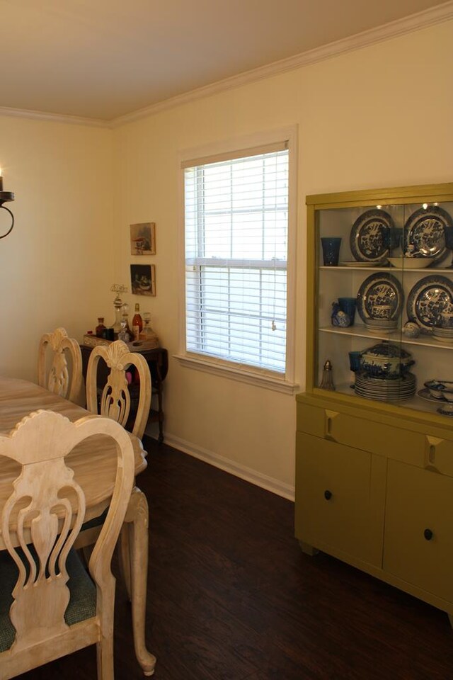 dining space with baseboards, ornamental molding, and dark wood-type flooring