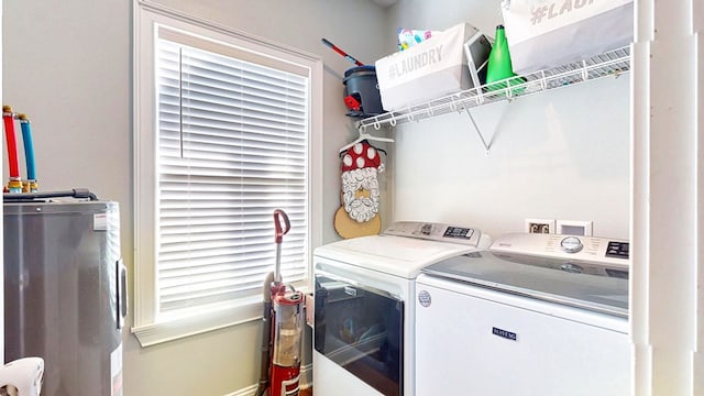 washroom featuring laundry area, washing machine and dryer, and water heater