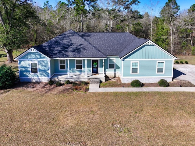 view of front of property with a front lawn, board and batten siding, a porch, and a shingled roof