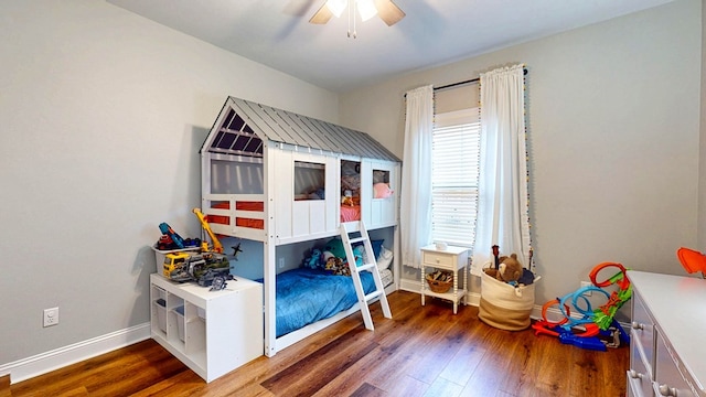 bedroom with ceiling fan, baseboards, and wood finished floors