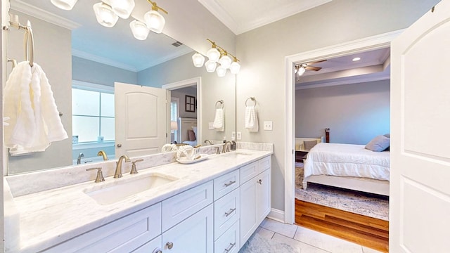 bathroom with double vanity, ensuite bath, ornamental molding, and a sink