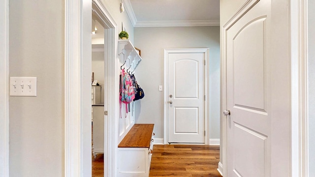 corridor with baseboards, ornamental molding, and wood finished floors