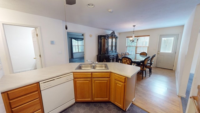 kitchen featuring hanging light fixtures, plenty of natural light, sink, and white dishwasher