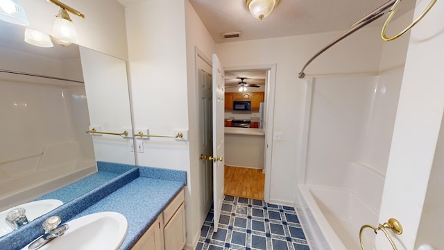 bathroom with vanity, tub / shower combination, and a textured ceiling