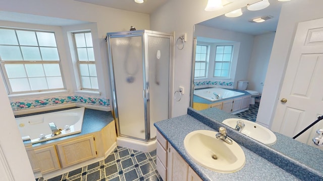 full bathroom with independent shower and bath, vanity, a wealth of natural light, and toilet