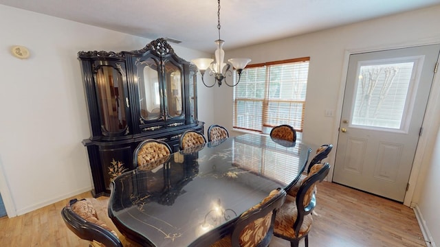 dining space featuring a notable chandelier and light hardwood / wood-style floors