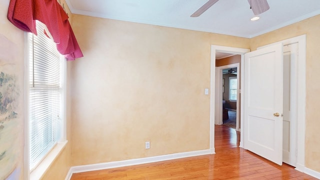 unfurnished bedroom featuring light hardwood / wood-style flooring, crown molding, and multiple windows