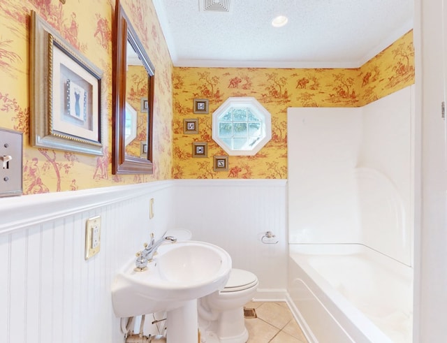 bathroom featuring tile patterned floors, sink, toilet, a textured ceiling, and a bathing tub